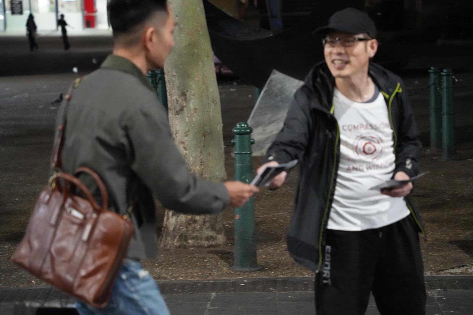 活动参与者向路人派发宣传资料