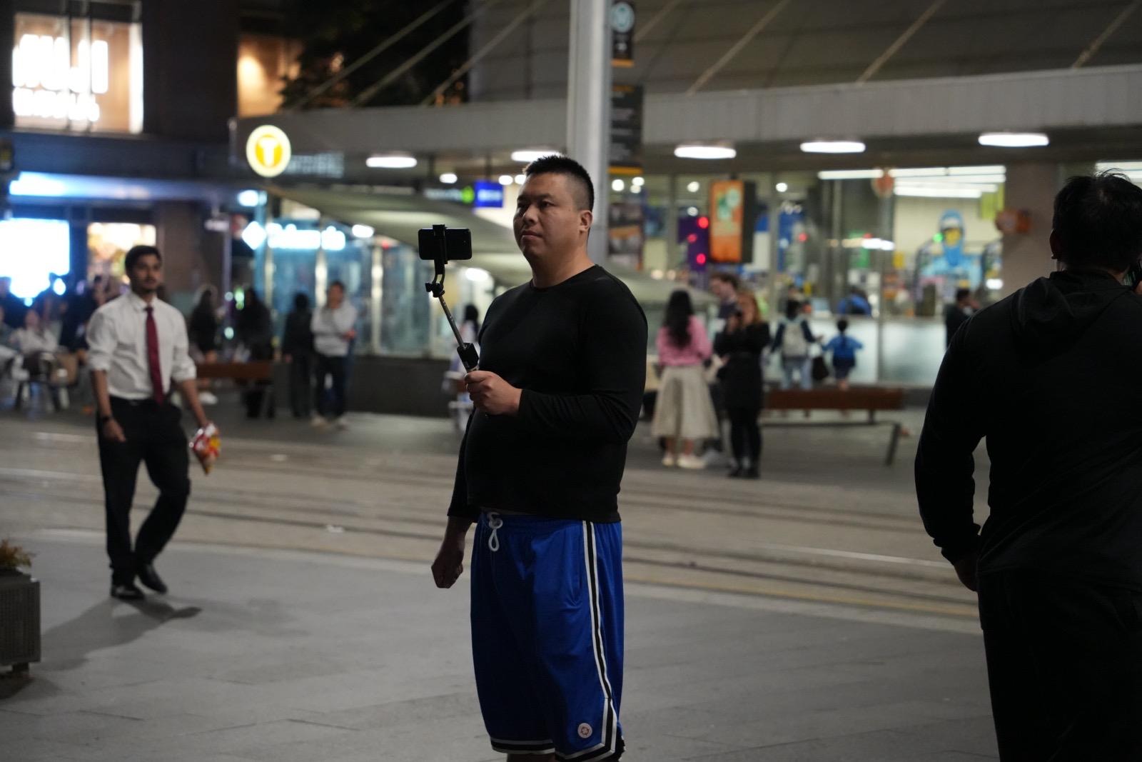 活动参与者在悉尼市中心记录现场情况